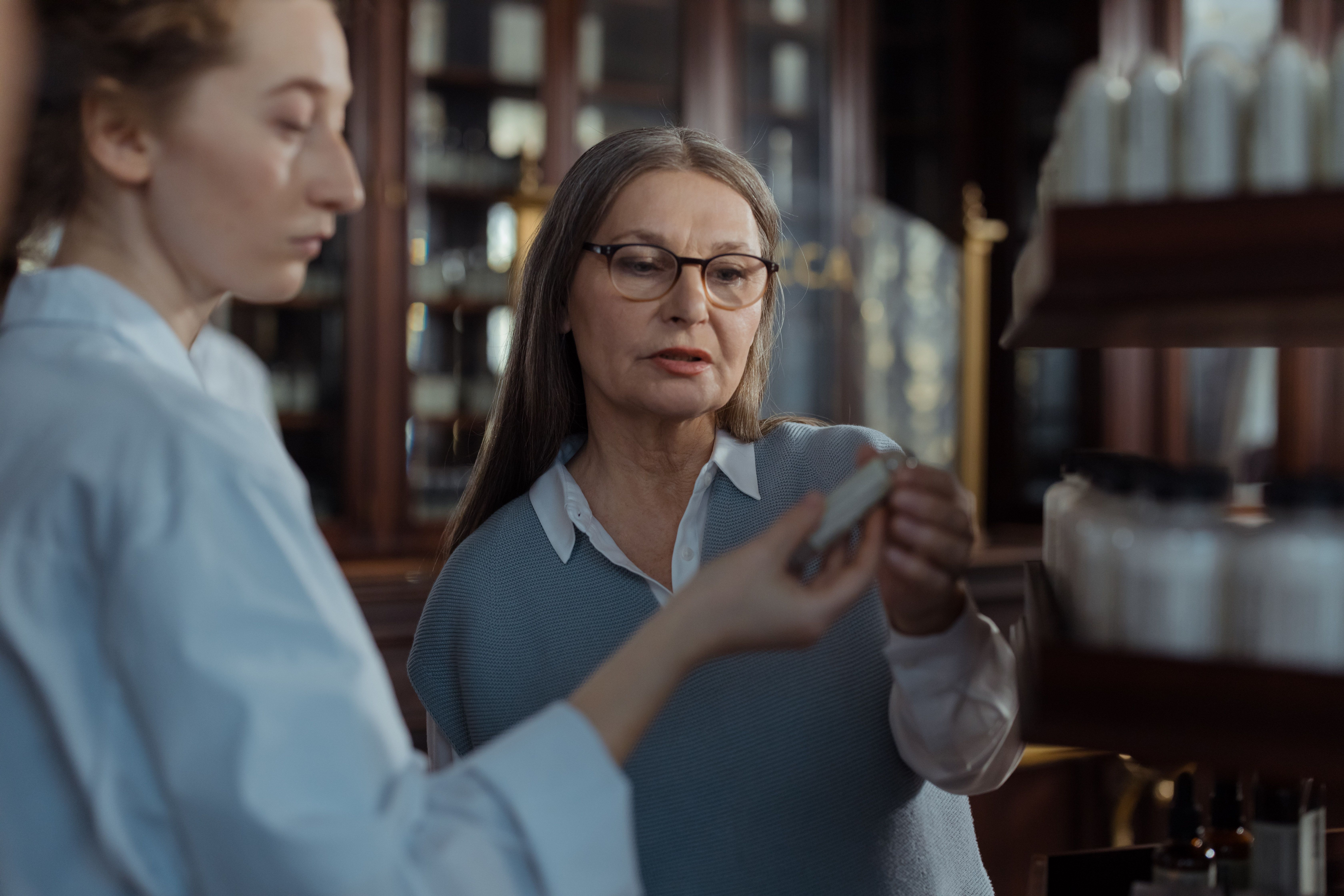 Pharmacist discussing medication options and instructions with an older patient